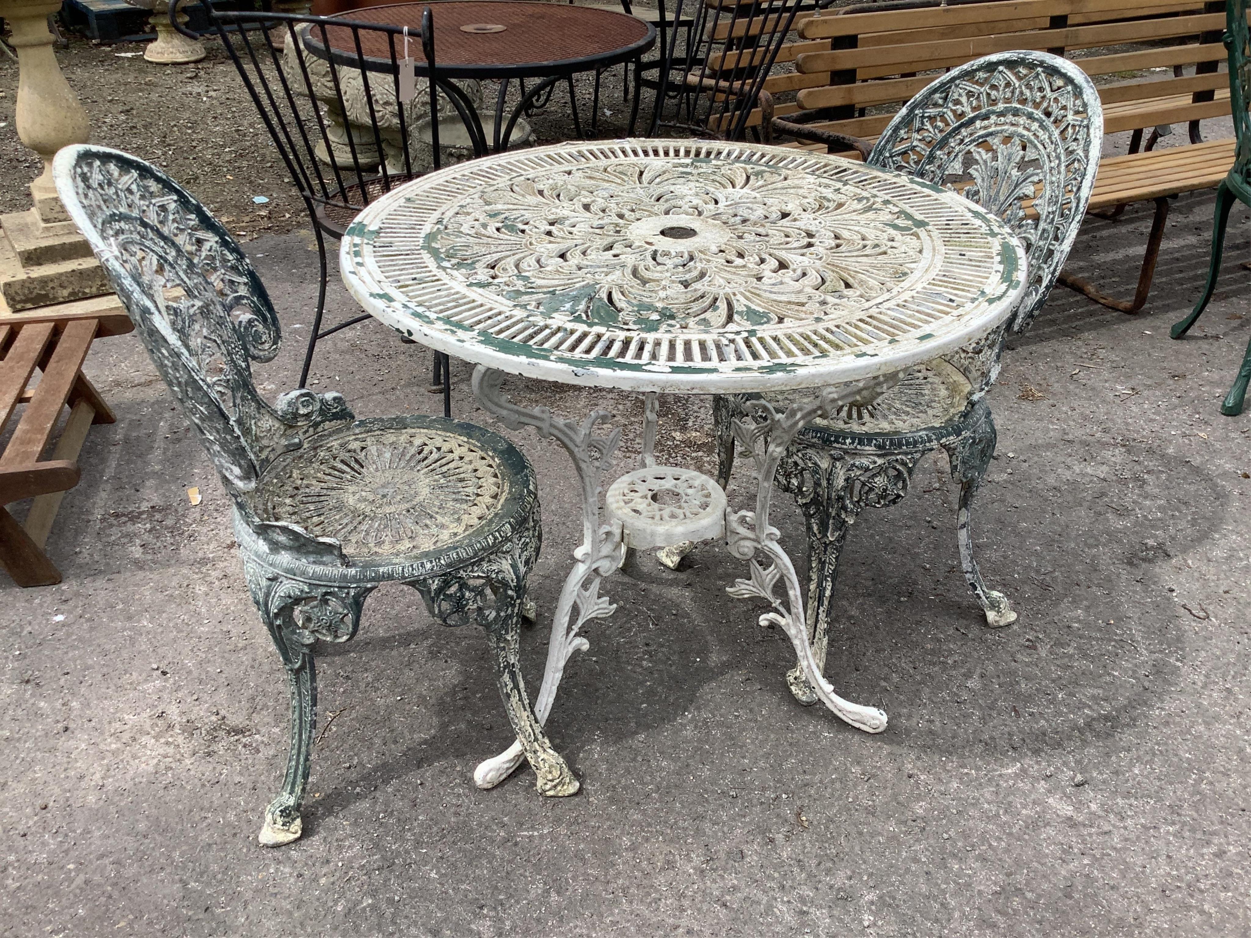 A Victorian style circular painted aluminium garden table, diameter 80cm, height 72cm and two chairs
